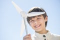 Boy Playing With Pinwheel Against Clear Blue Sky Royalty Free Stock Photo