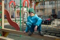 A boy is playing on playground in city yard