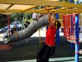 A boy is playing on a playgroung in one of the Brisban`s park Australia