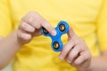 A boy is playing a popular toy fidget spinner in his hands. Stress relief. Anti stress and relaxation fidgets spinner.