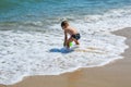 The boy is playing at sea with a bucket. Little boy having beach fun Royalty Free Stock Photo