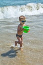 The boy is playing at sea with a bucket. Little boy having beach fun Royalty Free Stock Photo