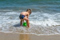 The boy is playing at sea with a bucket. Little boy having beach fun Royalty Free Stock Photo