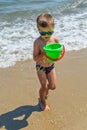 The boy is playing at sea with a bucket. Little boy having beach fun Royalty Free Stock Photo