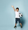 Cute boy playing football, happy child, young male teenager goalkeeper enjoying sports game, holding ball Royalty Free Stock Photo