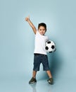 Boy playing football, happy child, young male teen goalkeeper enjoying sport game, holding ball, portrait of a preteen smiling Royalty Free Stock Photo