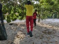 A boy is playing soccer under a tree in their yard while doing the famous soccer player style after scoring a goal.