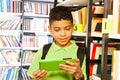 Boy playing with tablet in library Royalty Free Stock Photo