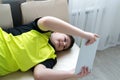 Boy playing on tablet while lying on couch