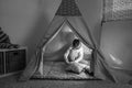 Boy playing in the teepee