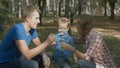 Boy is playing together with his parents. They are playing with soap-bubbles. Royalty Free Stock Photo