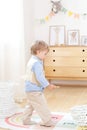 Boy playing with toys in the room. Eco-friendly children`s room decor in the Scandinavian style. Portrait of a boy playing in kind