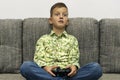 Boy playing video games with joystic sitting on sofa Royalty Free Stock Photo