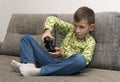 Boy playing video games with joystic sitting on sofa Royalty Free Stock Photo