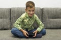 Boy playing video games with joystic sitting on sofa Royalty Free Stock Photo