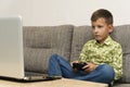 Boy playing video games with joystic sitting on sofa Royalty Free Stock Photo