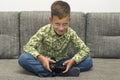 Boy playing video games with joystic sitting on sofa Royalty Free Stock Photo