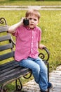 Boy playing with a walkie talkie on a street in a playground wit