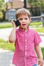 Boy playing with a walkie talkie on a street in a playground wit