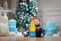 Boy playing with wooden alphabet blocks against Christmas tree Royalty Free Stock Photo