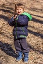 A boy is playing with a wooden stick in the woods Royalty Free Stock Photo