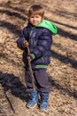 A boy is playing with a wooden stick in the woods Royalty Free Stock Photo