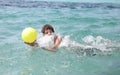 Boy plays with the ball in the tropical water Royalty Free Stock Photo