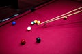 Boy plays billiard or pool in club. Young Kid learns to play snooker. Boy with billiard cue strikes the ball on table. Royalty Free Stock Photo