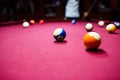 Boy plays billiard or pool in club. Young Kid learns to play snooker. Boy with billiard cue strikes the ball on table. Royalty Free Stock Photo