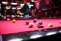 Boy plays billiard or pool in club. Young Kid learns to play snooker. Boy with billiard cue strikes the ball on table. Royalty Free Stock Photo