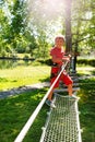 Boy plays in the children rope net playground