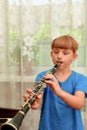 The boy plays the clarinet at a music school