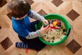 Boy plays game, grain and groats with small toys are poured into a basin, a child plays, development of autism and a game for