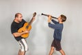 The boy plays the guitar and clarinet in different poses, posing in the studio