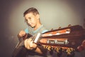 A boy plays the guitar on a gray background in the studio, wide-angle close-up photo Royalty Free Stock Photo