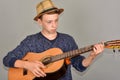 A boy plays the guitar on a gray background in the studio, wide-angle close-up photo Royalty Free Stock Photo