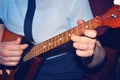 The girl is playing dombra and beating the chords on the guitar, close-up.