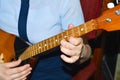 The girl is playing dombra and beating the chords on the guitar, close-up.