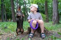 A boy plays with his dog a dachshund, trains, a dog fulfills a command to stand on two paws, for a walk in a green park