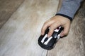 The boy plays at home on a light floor. Black car in the hands on a pastel background