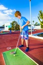 Boy plays minigolf