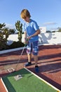 Boy plays minigolf