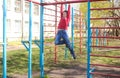 A boy plays outdoors on the playground.