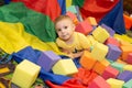 A boy plays in a playground with cubes. Foam dry pool. A boy builds a castle from cubes. Royalty Free Stock Photo