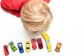 Boy plays with toy cars at home high angle view from directly above child