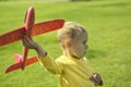 A boy plays in a toy red plane Royalty Free Stock Photo