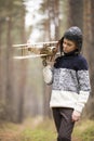 A boy plays in the woods with a toy plane. autumn games in the w Royalty Free Stock Photo