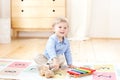 The boy plays xylophone at home. Cute smiling positive boy playing with a toy musical instrument xylophone in the children`s white Royalty Free Stock Photo