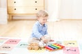 The boy plays xylophone at home. Cute smiling positive boy playing with a toy musical instrument xylophone in the children`s white Royalty Free Stock Photo