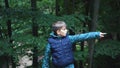 Boy points in the direction of the forest